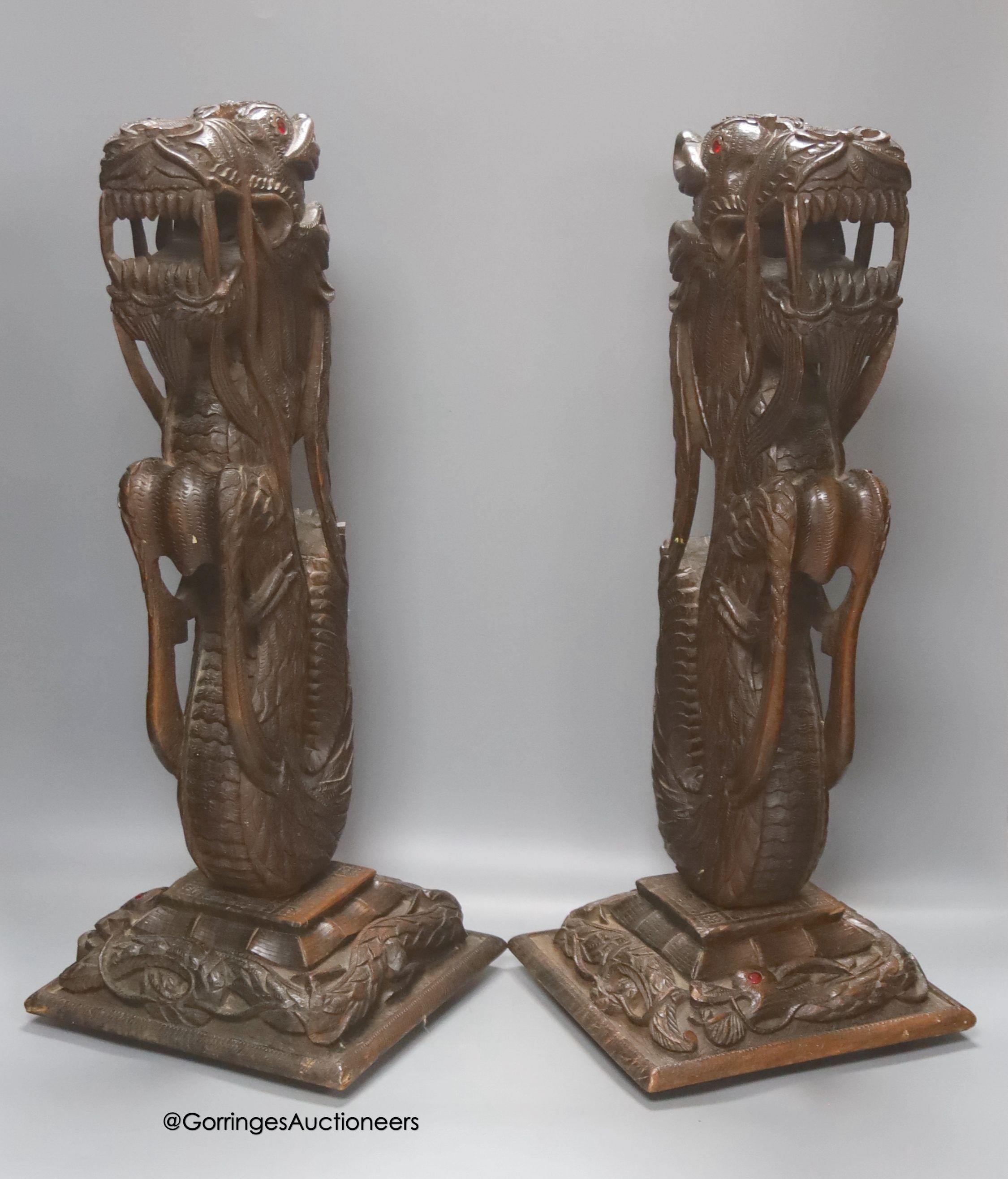 A pair of Burmese carved hardwood 'dragon' lamps, height 50cm, lacking light fittings